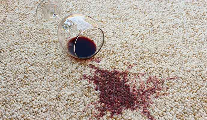 Wine glass on the carpet and visible wine stain