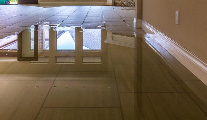 Room with tiled floor, partially flooded with water